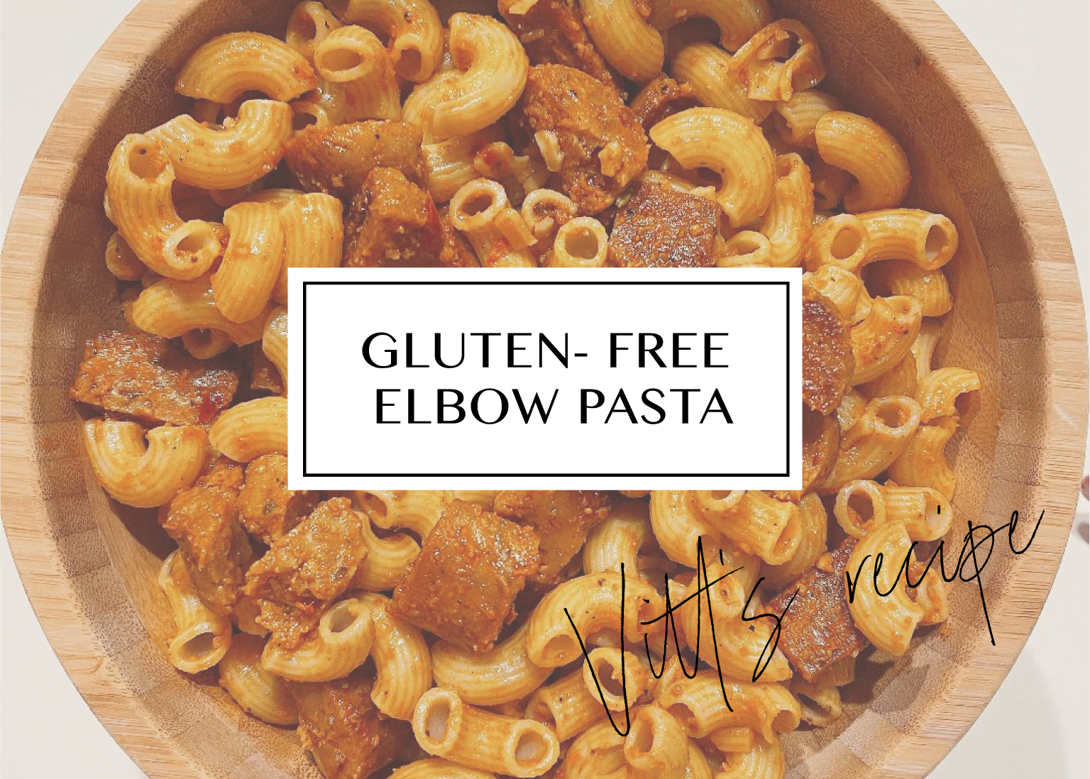 Gluten-free elbow pasta in roasted red pepper sauce with vegan sausage, in a wooden bowl.