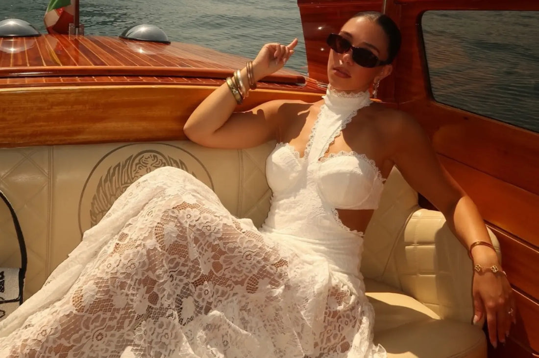 Mesh maxi dress worn by a woman lounging on a wooden boat in the sun.