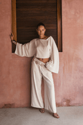 Model wearing the 12th Tribe Clear Breeze White Linen Pants, a best-selling style in a new color featuring a versatile fit that can be worn low or mid-rise, perfect for pairing with crop tops, tanks, or blouses for summer soirées, vacation looks, and effortless warm-weather outfits. Get the full set with the Clear Breeze White Linen Top