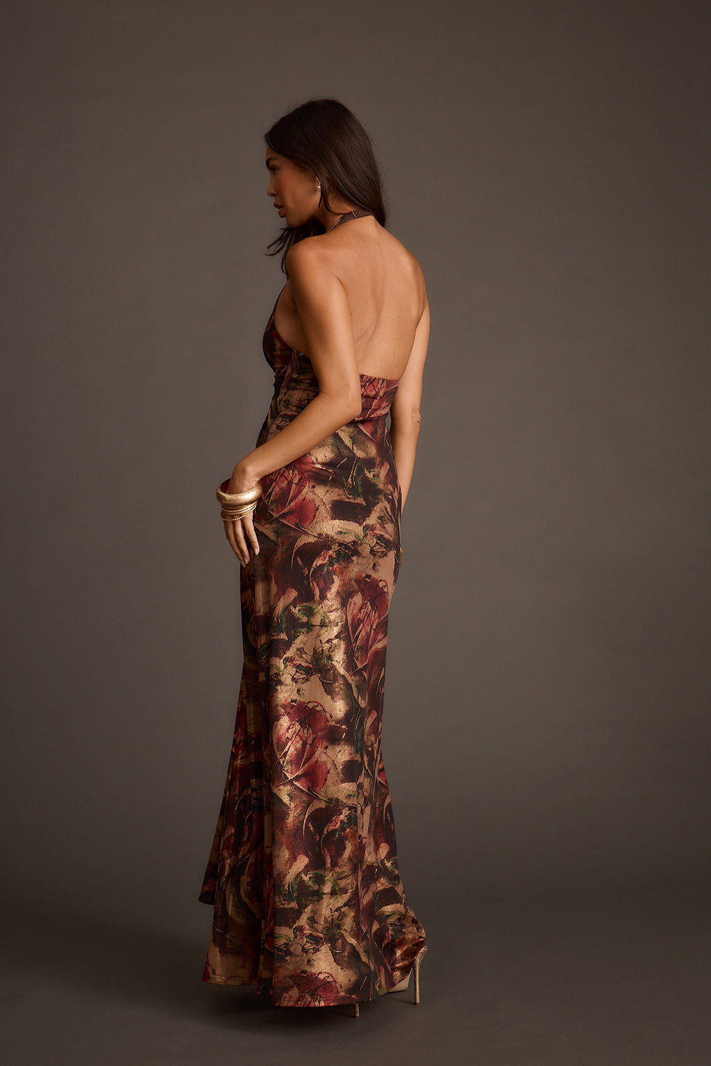 Backless halter maxi dress with a metallic floral print and floor-length hem.