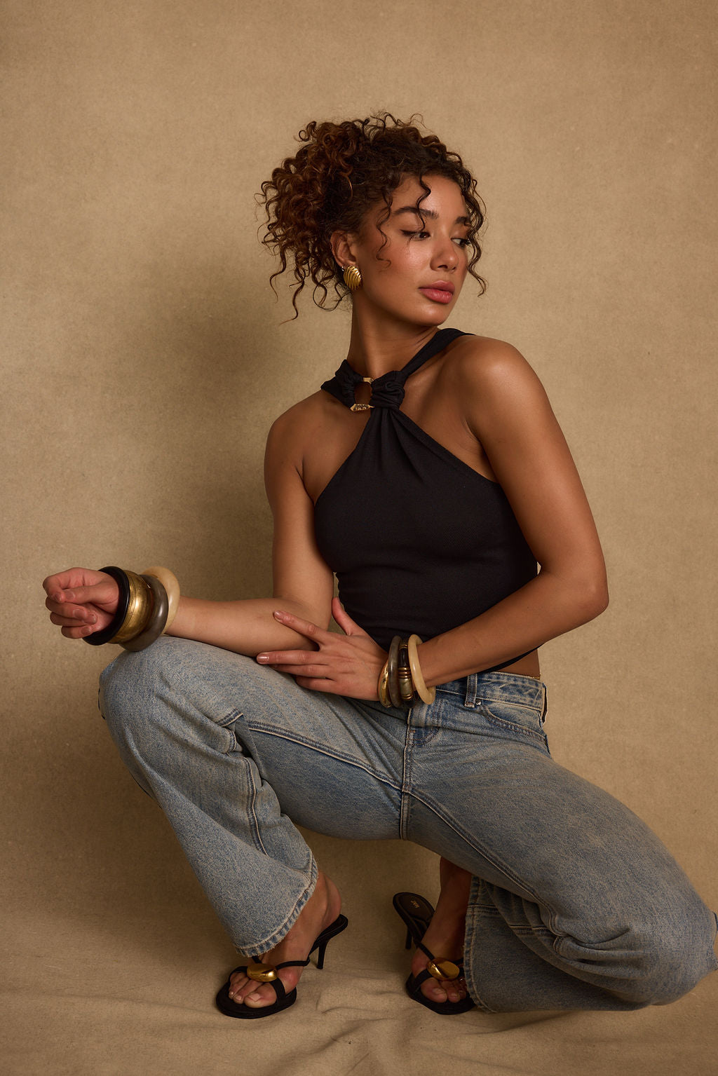 Lifestyle shot of the black halter top styled for day-to-night versatility.