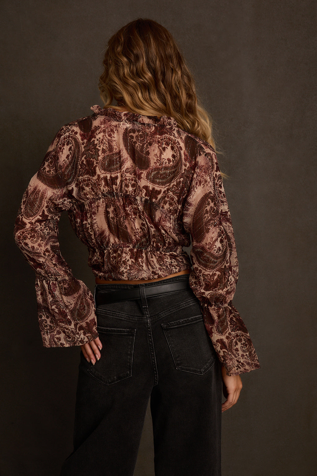 Women's blouse back view showing elasticized waist and bell sleeve silhouette