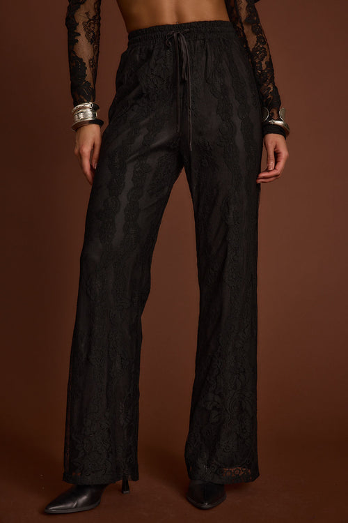Back view of the black lace pants showing the silhouette and fit.