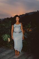 Model wearing the 12th Tribe Amelie Blue Embellished Midi Dress, featuring intricate gunmetal beadwork, a fitted midi silhouette, and adjustable straps, styled with heels for bachelorette parties, cocktail events, and evening outings