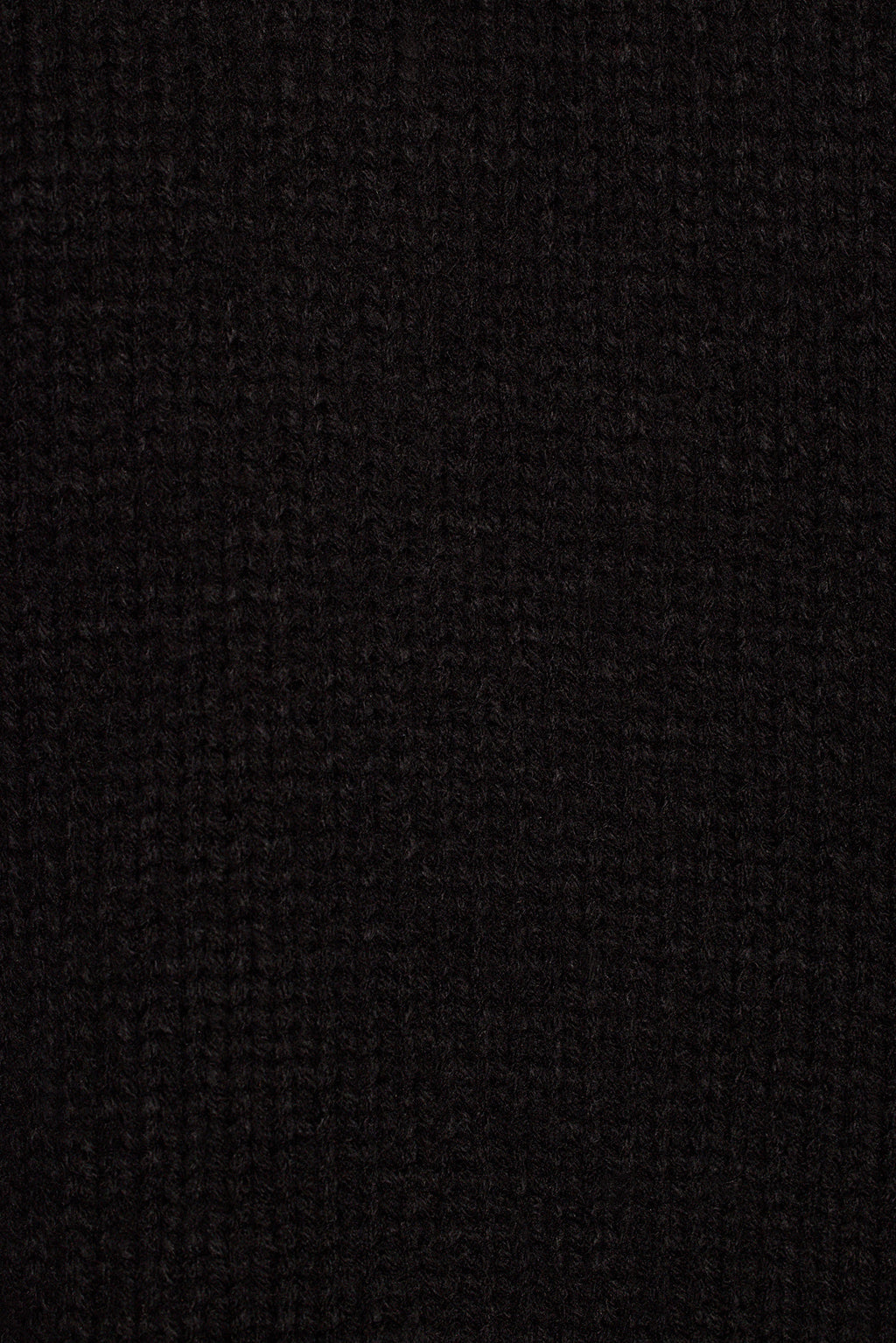 Black knit sweater fabric close-up showing soft fuzzy texture and ribbed collar detail