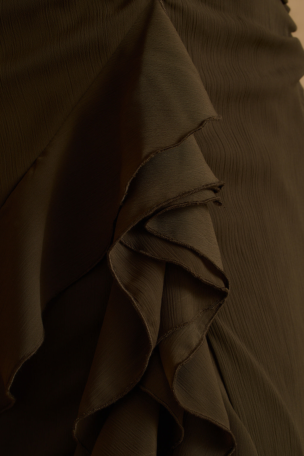 Close-up of cascading ruffle detail on the olive Aria halter maxi dress skirt.