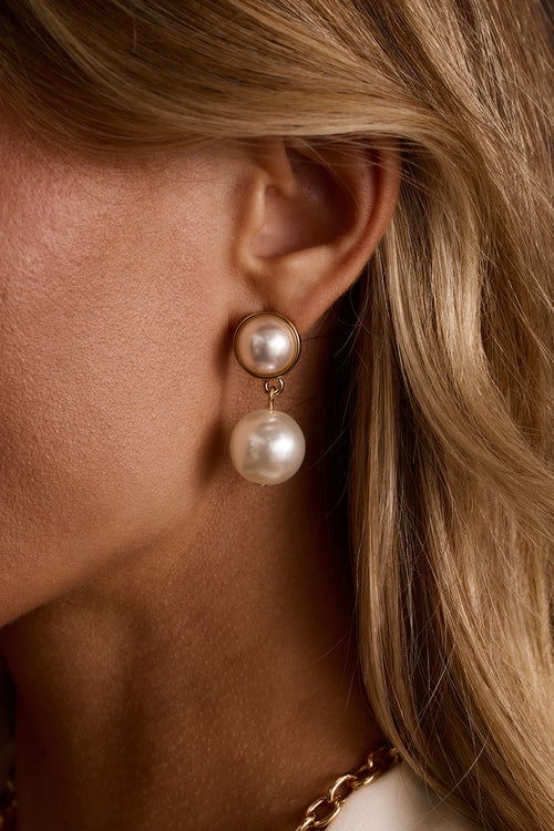 Bellami double pearl drop earrings with gold settings shown on-model against blonde hair.