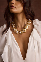 Model wearing the 12th Tribe Bloom Pearl Choker in gold and pearl. Featuring a chunky style statement necklace, gold-tone clasp, styled layered with other necklaces or worn solo for bachelorette parties, weddings, and everyday elevated looks