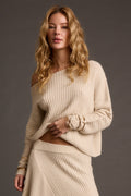 Cream sweater with refined detailing and a flattering silhouette.