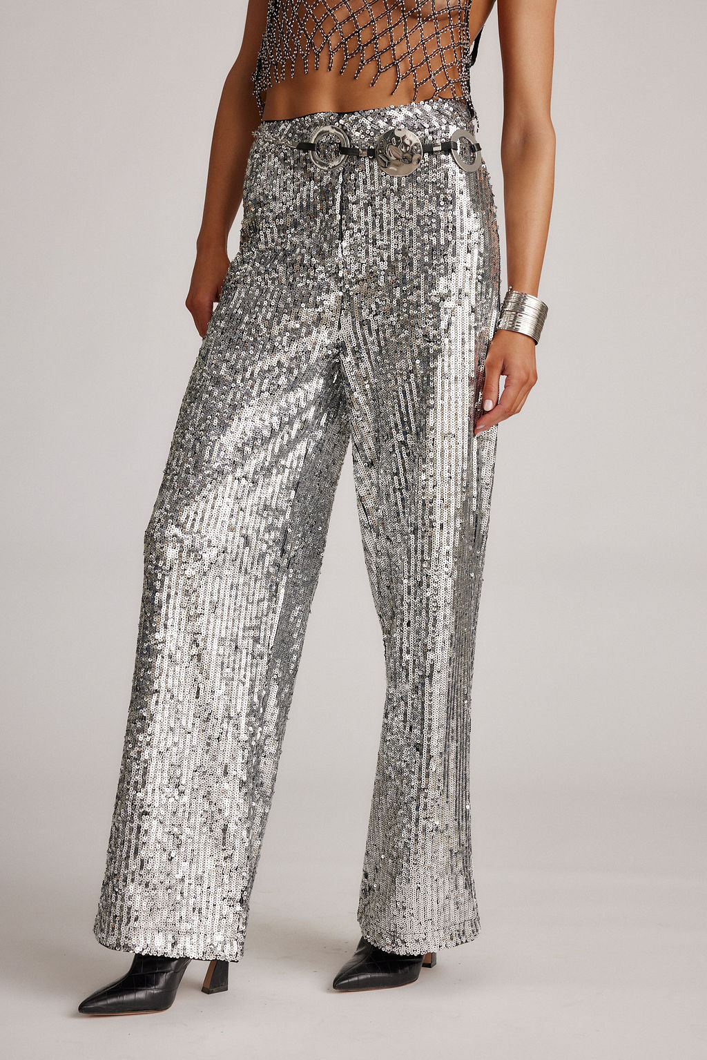 Lifestyle shot of the silver trousers styled for day-to-night versatility.