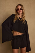Black linen top with refined accents, a black fringe top essential.