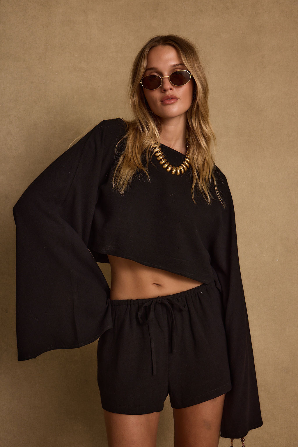 Black linen top with refined accents, a black fringe top essential.