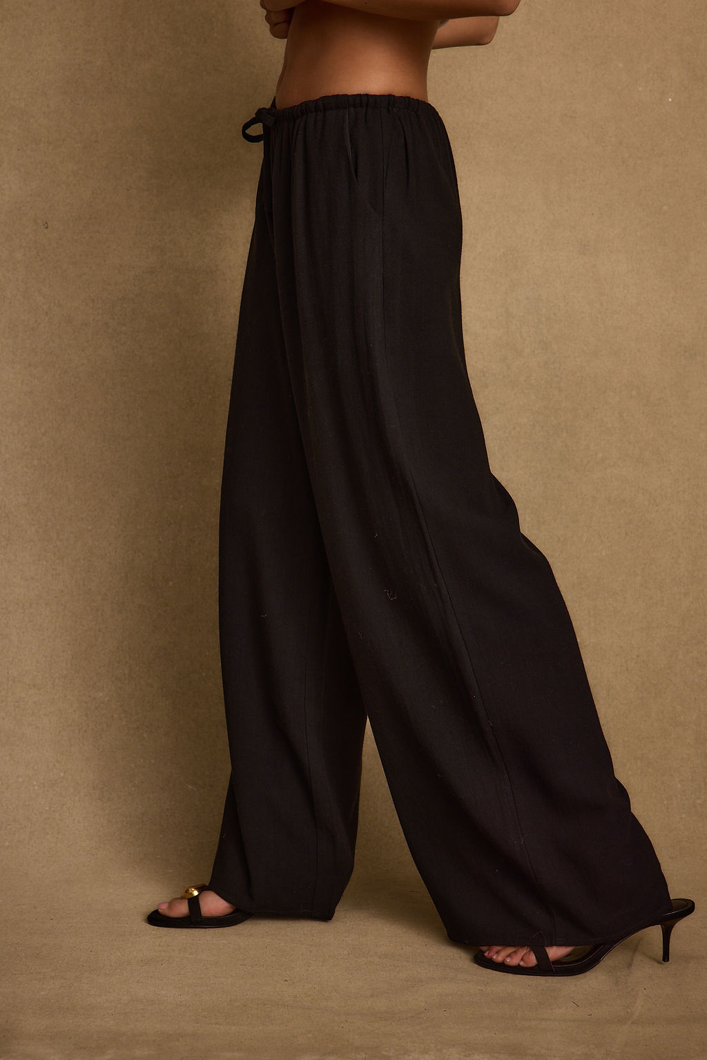 Full-length view of the black pants showing the drape and movement.