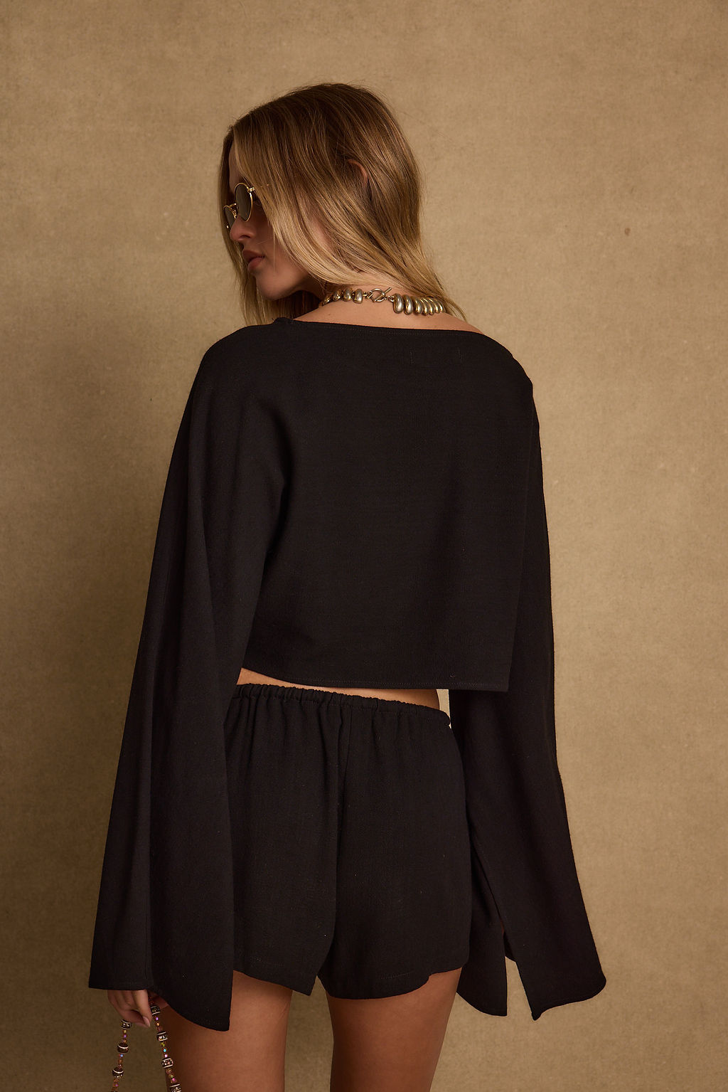 Full-length view of the black top showing the drape and movement.