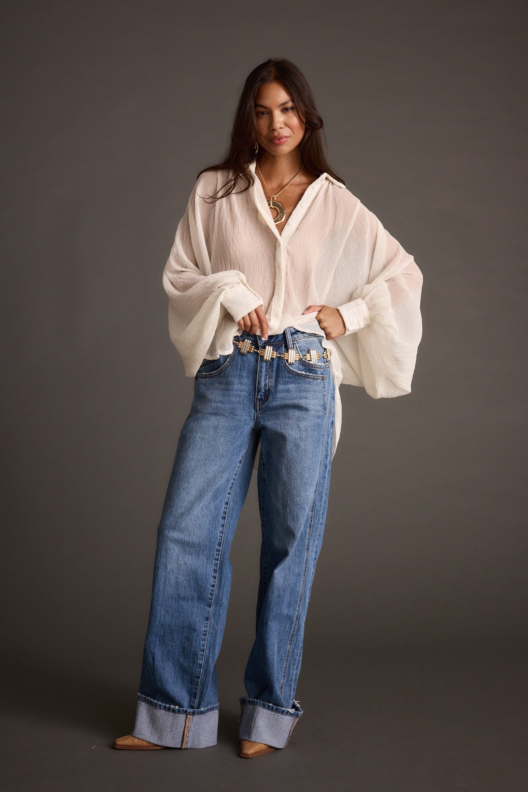 Full-length view of the ivory blouse showing the drape and movement.