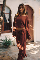Model wearing the 12th Tribe Clear Breeze Rust Linen Pants with the matching Clear Breeze Rust Linen Top, featuring breathable linen fabric, a relaxed wide-leg silhouette, and a stunning warm rust tone.