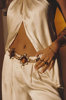 Model wearing the 12th Tribe Coralli Amber Stone Statement Belt, featuring amber stone detailing, styled with the Moonlit Kiss Cream Satin Trousers and Moonlit Kiss Cream Satin Halter Top.