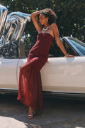 Strapless burgundy lace maxi dress with a fitted bodice and pleated flared hem.