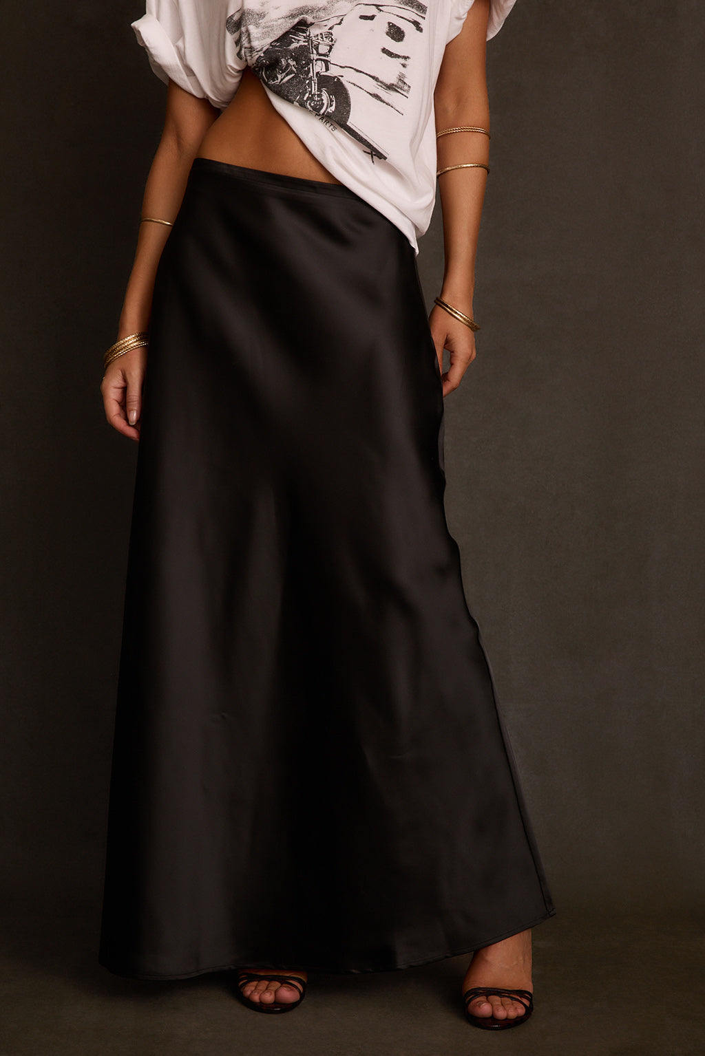 Black skirt side angle showing smooth satin sheen and floor-length silhouette