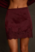 Satin skirt styled as matching set with cape top, gold bangles, and strappy heels