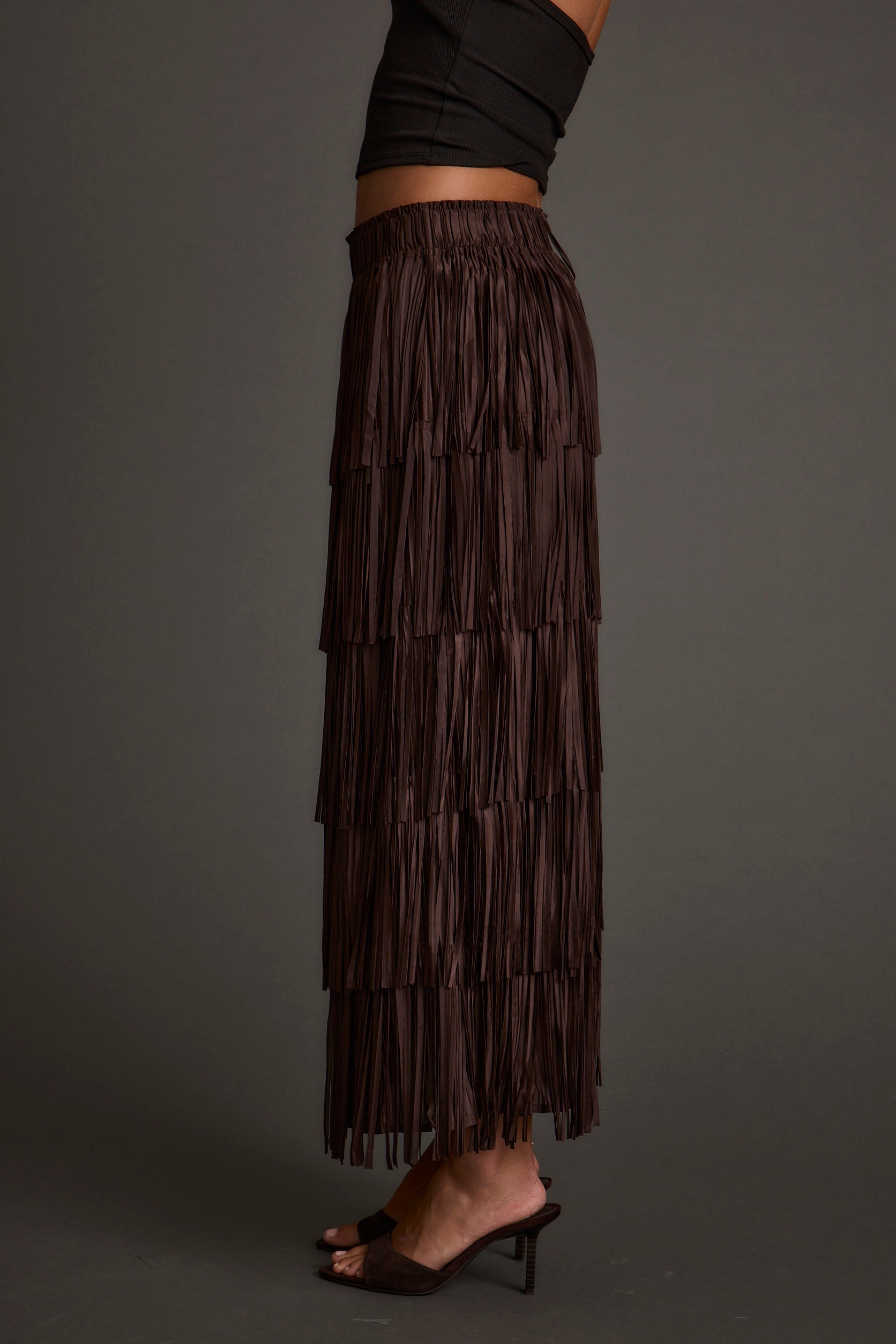 Detail shot of the Eliza Espresso Fringe Maxi Skirt highlighting the fringe elements.
