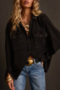 Shacket in washed black waffle knit with front pockets, open over denim with gold belt