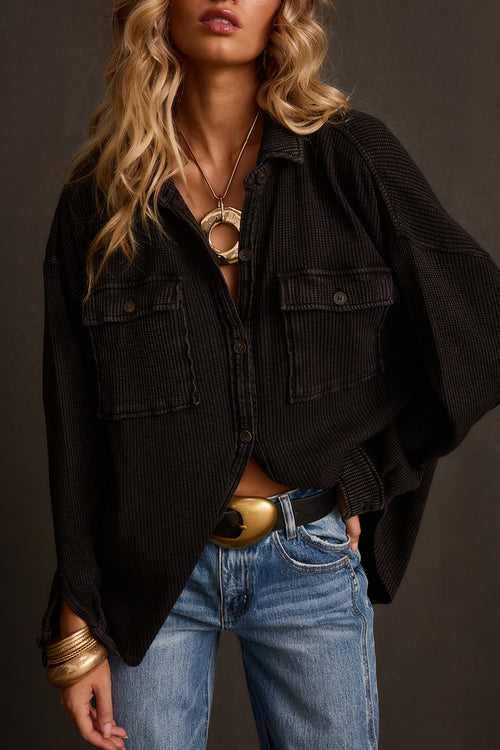 Shacket in washed black waffle knit with front pockets, open over denim with gold belt