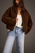 Woman wearing mocha vegan suede jacket over cream tank top with wide-leg jeans, front view