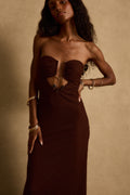 Close-up of espresso strapless maxi dress showing textured knit, front cutout and stone hardware detail.