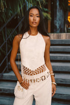 Model wearing the 12th Tribe Liora Ivory Jacquard Halter Top, featuring a textured jacquard fabric, a halter neckline, and a cropped silhouette, styled with high-waisted skirts or pants and accessorize for brunches, festivals, wedding events, and evening outings