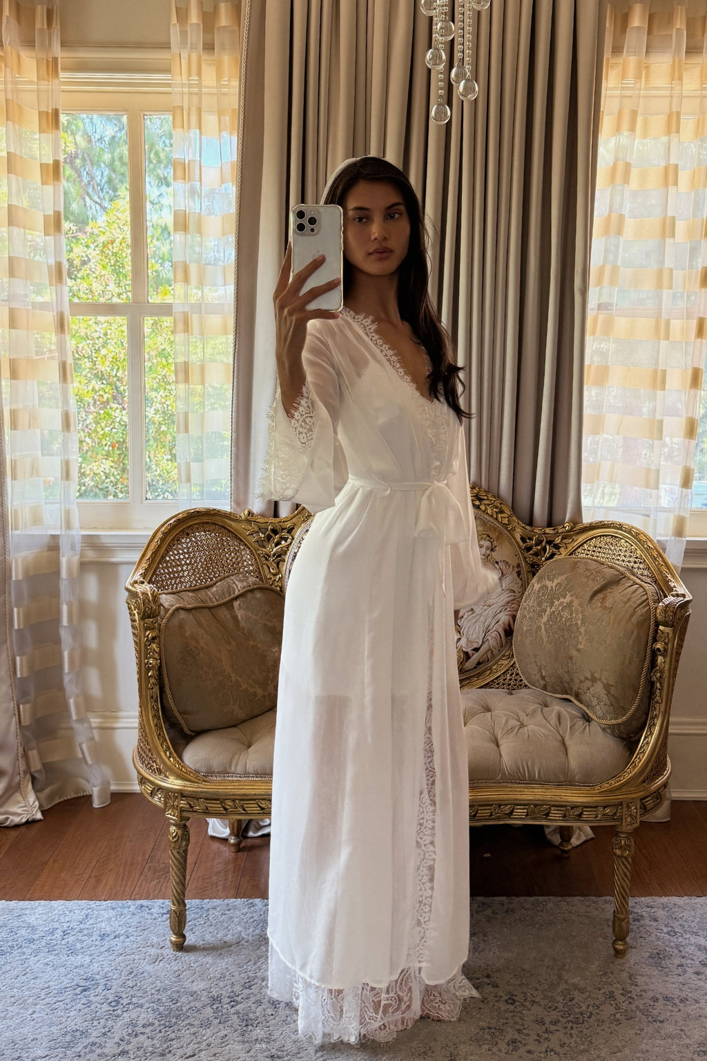 White lace-trimmed robe with bell sleeves and a tied waist sash over a satin slip dress.