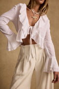 White ruffled blouse with refined detailing and a flattering silhouette.