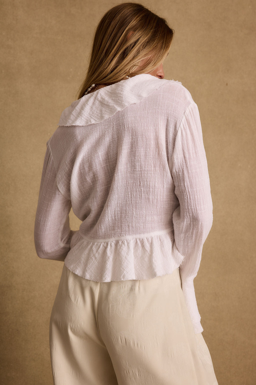 Lifestyle shot of the white blouse styled for day-to-night versatility.
