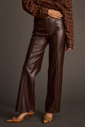 Woman wearing espresso brown vegan leather flare pants with a plaid wrap top and tan pointed-toe heels