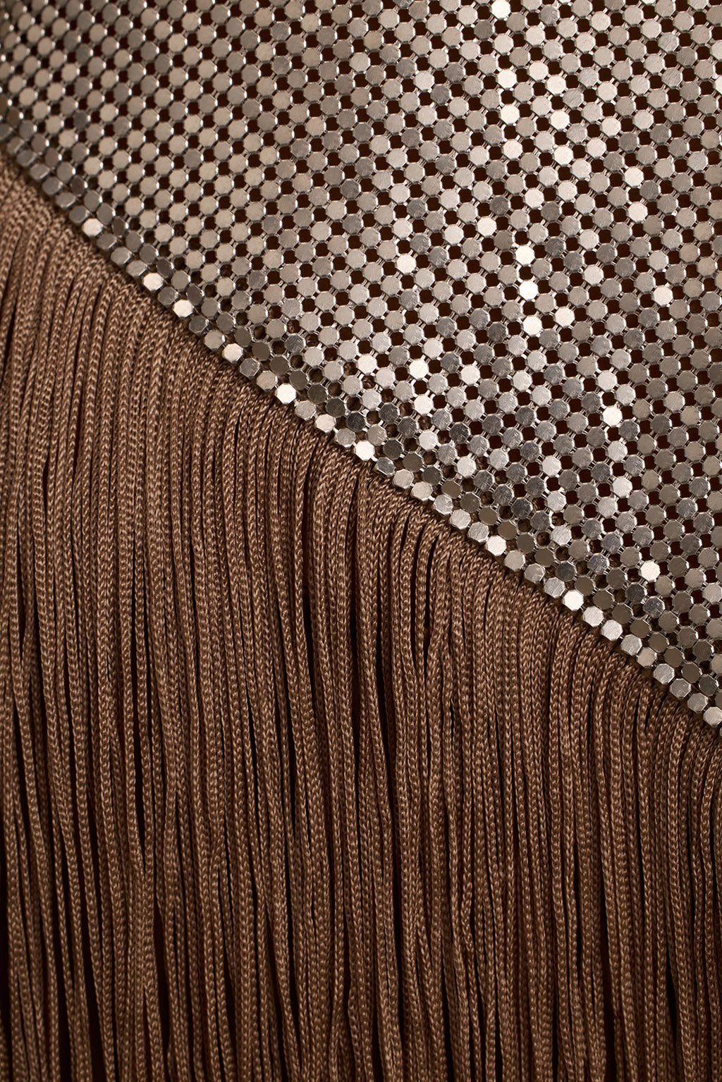 Close-up of silver chainmail mesh meeting long taupe fringe on the Haze halter top.