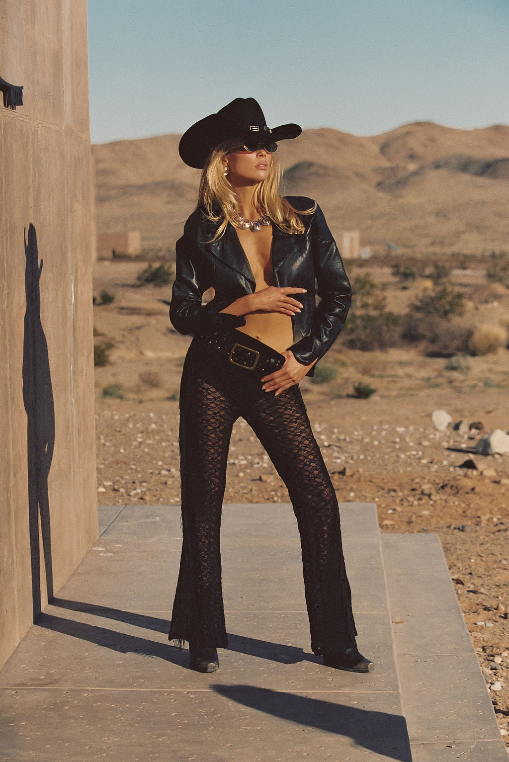 Model wearing the 12th Tribe Happy Hour Black Fringe Pant, sheer lace pants featuring fringe detailing along the side seams, a best-selling style in a new design, perfect for evening events, summer soirées, and festival-ready standout looks