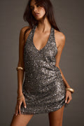 Woman wearing gunmetal sequin mini dress with halter neckline, front view