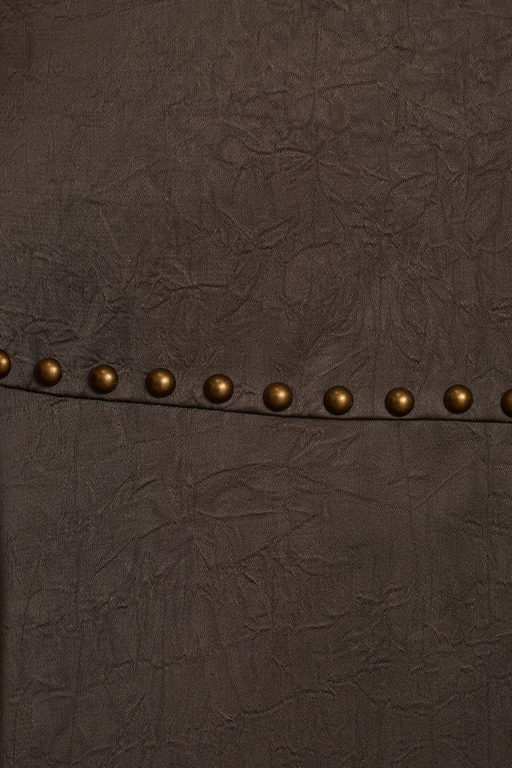 Slate satin fabric detail showing sheen and hammered stud embellishment close-up