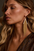 Gold earrings with V-shaped bar and cascading chainmail fringe, close-up profile view on model