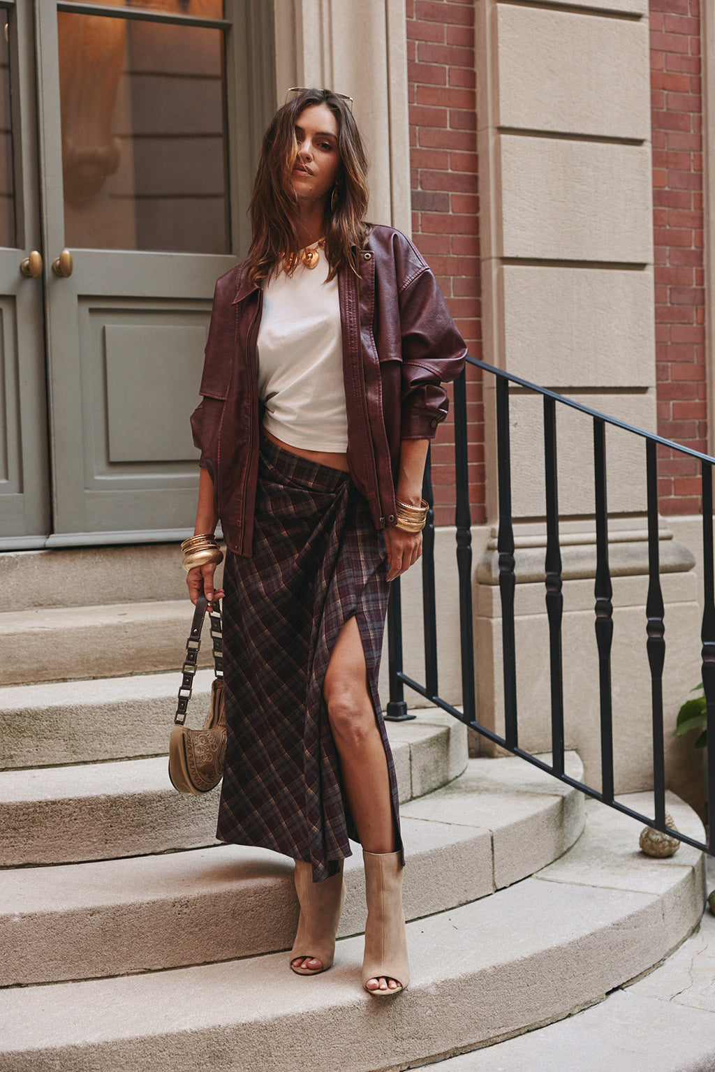 Faux leather jacket three-quarter angle styled with lace trim shorts and gold bangles