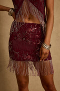 Model wearing the 12th Tribe Luna Cove Mulberry Mini Skirt in rich mulberry, featuring a high-waisted mini silhouette and tailored fit, styled with the matching Capri Mulberry Beaded Halter Top bachelorette parties, concerts, and vacation nights out.