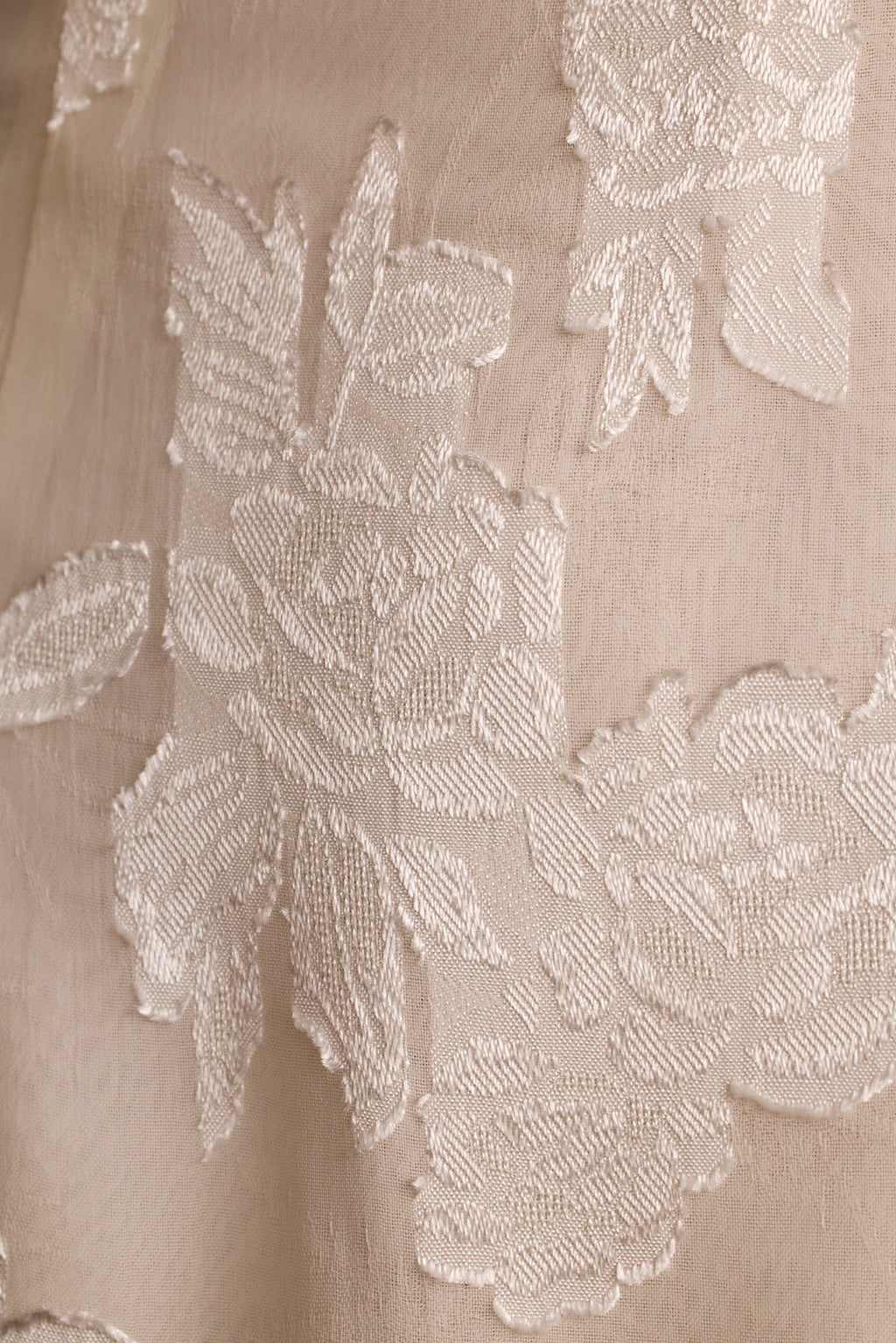 Close-up of ivory floral embroidery woven into the Marissa mini dress fabric.