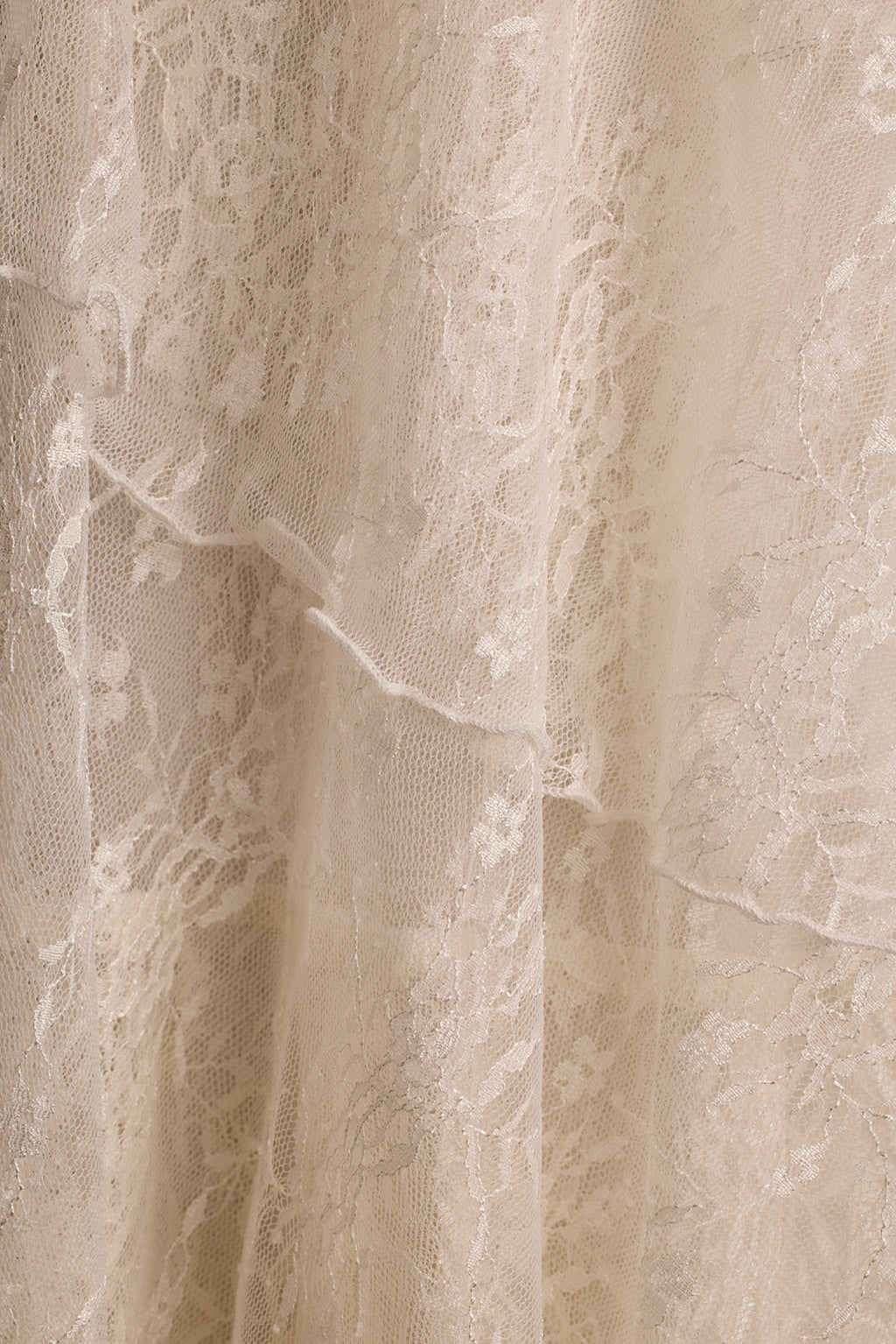 Close-up of cream floral lace fabric showing tiered layers on the Mon Amour maxi dress.