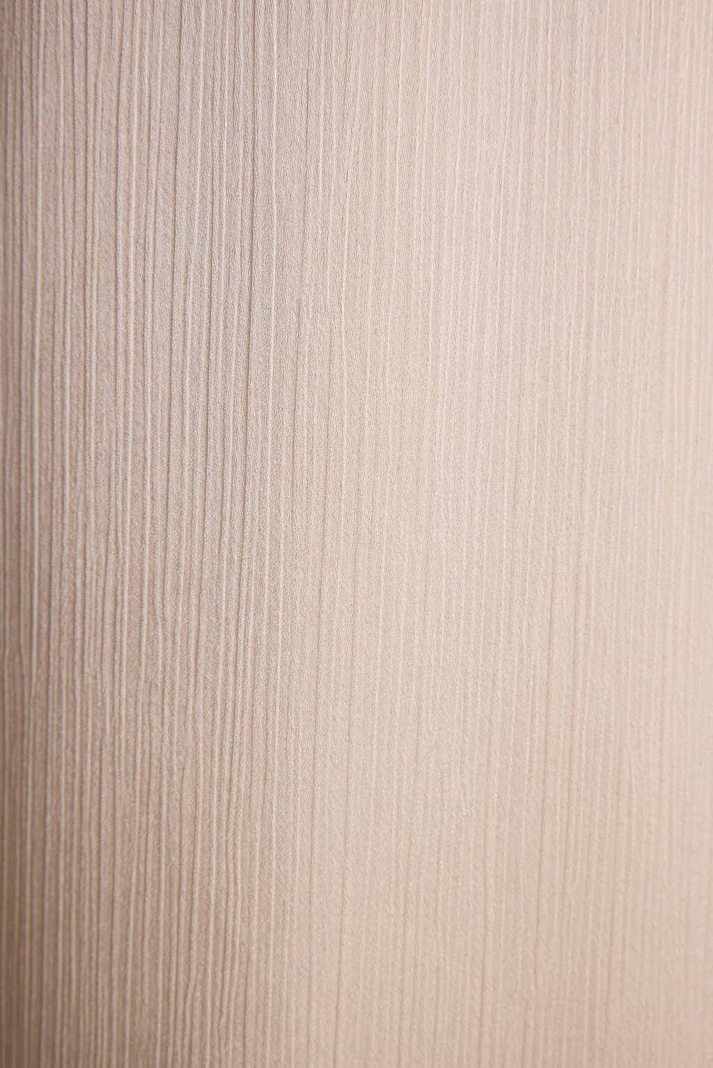 Lifestyle shot of the cream trousers styled for day-to-night versatility.