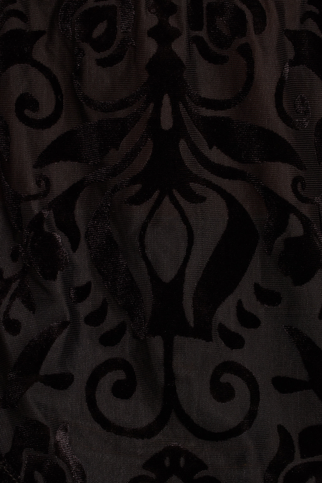 Black burnout velvet fabric detail showing damask scroll pattern and tassel fringe trim