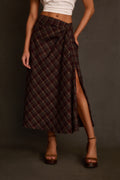 Maxi skirt in plaid with bias cut, twist waist detail, and side slit, styled with white tee