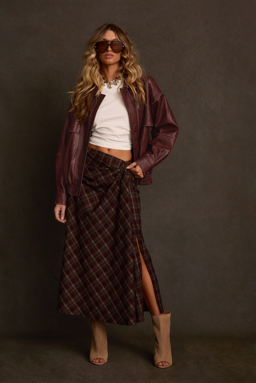 Maxi skirt styled outdoors with surplice sweater, fringe bag, and pointed boots
