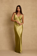 Model wearing the 12th Tribe Mirabella Chartreuse Satin Maxi Dress in light green satin. Featuring a flowing maxi silhouette and flattering plunge neckline. Style with strappy heels for bachelorette parties, festivals, and summer celebrations.