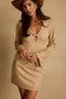 Full-length view of the gold mini dress showing the drape and movement.