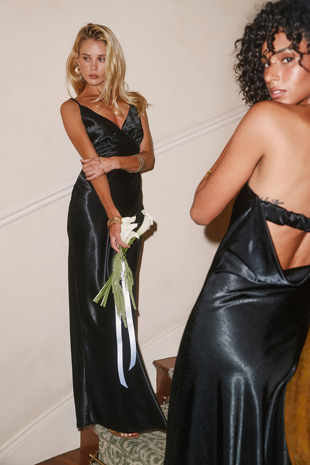 Black V-neck satin wrap dress paired with a black open-back strapless satin dress.